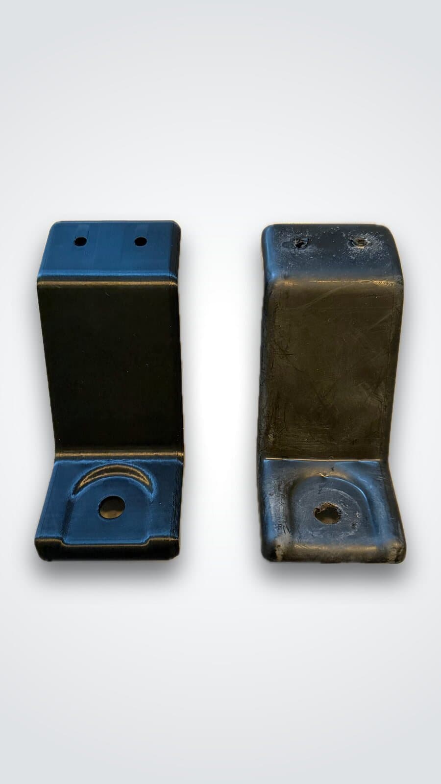 Deux équerres noires imprimées en 3D par Protofab, percées pour le montage