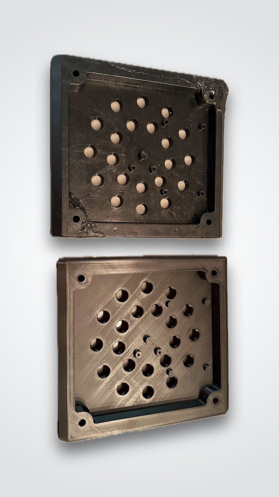 Deux plaques ventilées noires imprimées en 3D, l'une au-dessus de l'autre